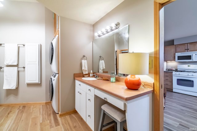 bathroom featuring stacked washer and clothes dryer, wood-type flooring, and sink