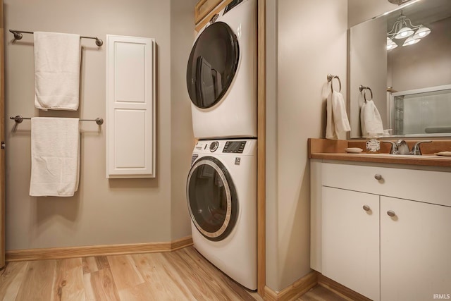 washroom with sink, stacked washer and clothes dryer, and light wood-type flooring