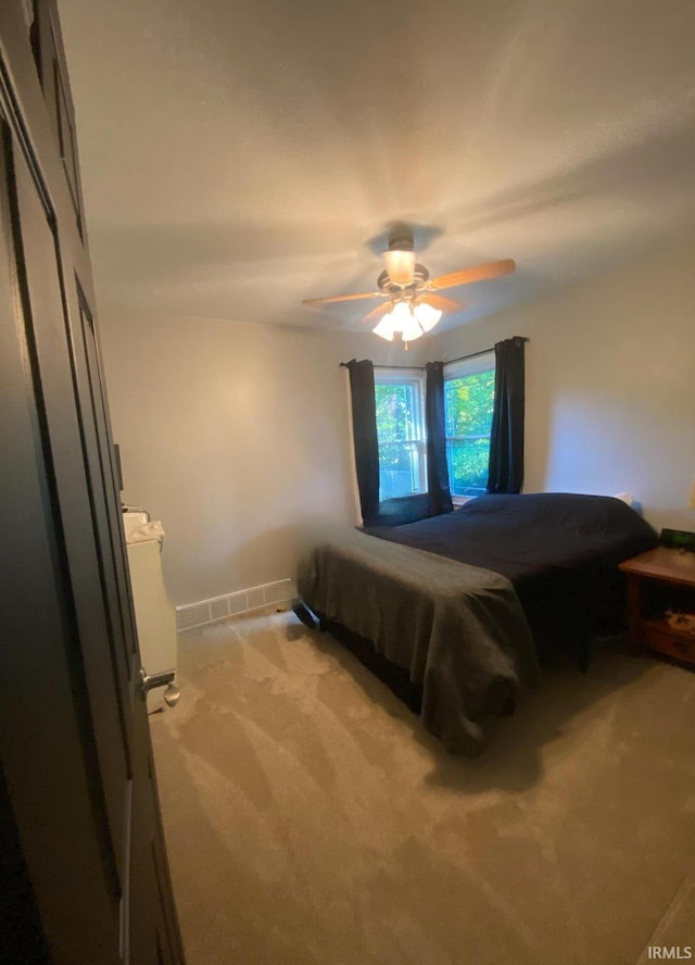 bedroom with ceiling fan and light colored carpet