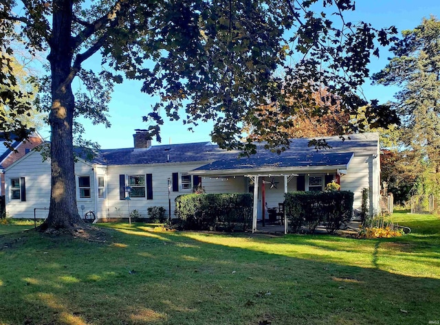 rear view of house featuring a lawn