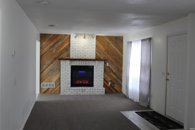 308 Clyde Ave, Angola, IN 46703 - unfurnished living room featuring carpet flooring, a brick fireplace, wood walls, baseboards, and visible vents