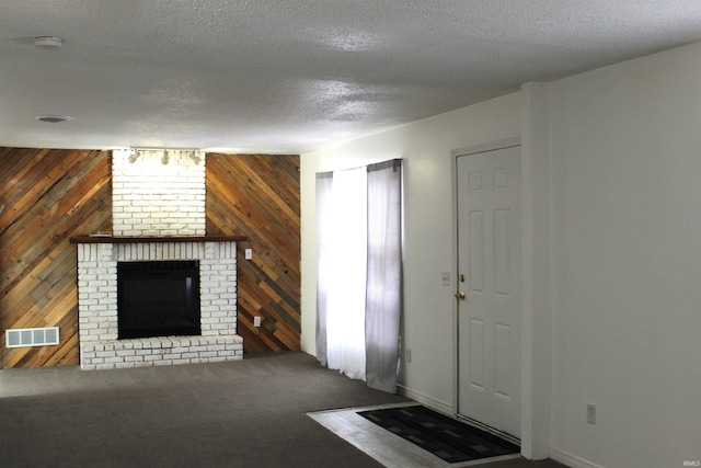 308 Clyde Ave, Angola, IN 46703 - carpeted foyer entrance with wooden walls, baseboards, visible vents, and a brick fireplace