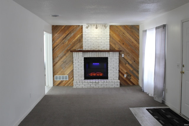 308 Clyde Ave, Angola, IN 46703 - unfurnished living room with a brick fireplace, wood walls, visible vents, and baseboards