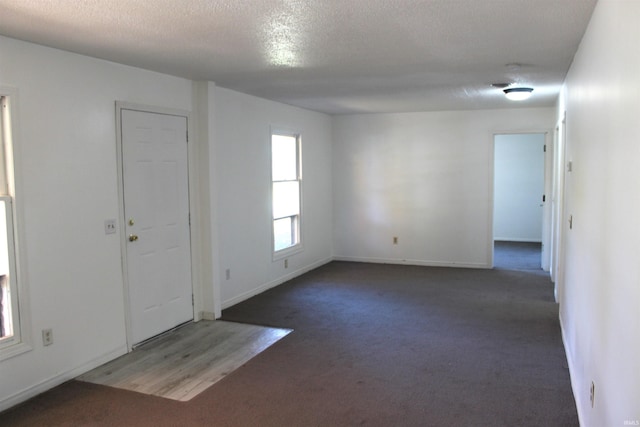 carpeted spare room with a textured ceiling