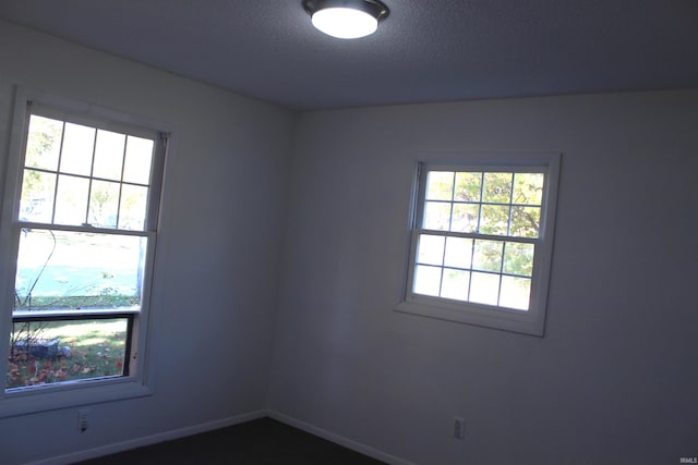 spare room with plenty of natural light and a textured ceiling