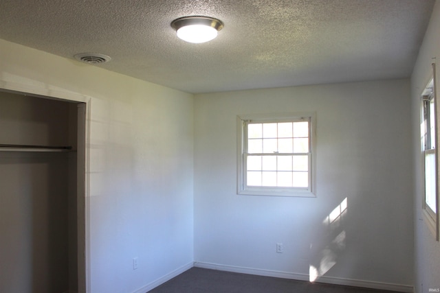 unfurnished bedroom featuring a textured ceiling and a closet