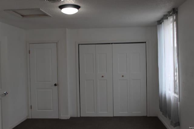 308 Clyde Ave, Angola, IN 46703 - unfurnished bedroom featuring dark colored carpet, a textured ceiling, and a closet