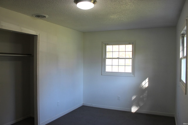 unfurnished bedroom with a textured ceiling and a closet