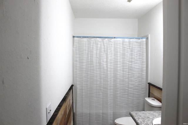 bathroom featuring a shower with curtain, vanity, and toilet