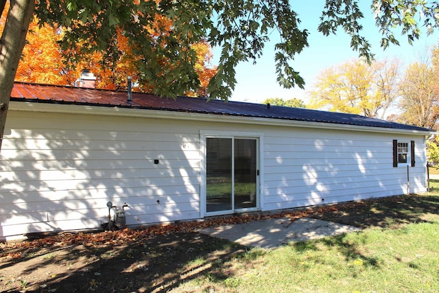 308 Clyde Ave, Angola, IN 46703 - rear view of property featuring a chimney, a yard, and metal roof