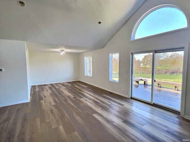 unfurnished living room featuring dark wood-type flooring and high vaulted ceiling