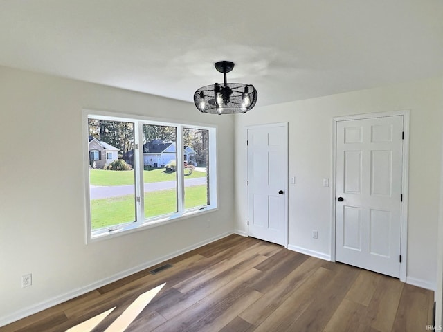 interior space featuring wood-type flooring and an inviting chandelier