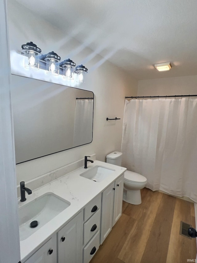 bathroom featuring vanity, walk in shower, hardwood / wood-style flooring, and toilet