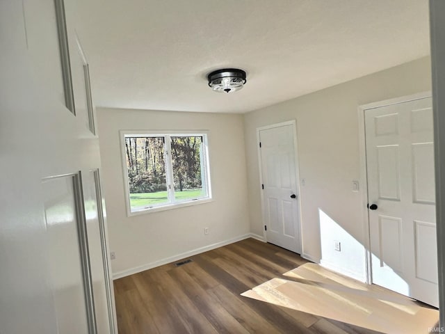 unfurnished bedroom with dark hardwood / wood-style floors