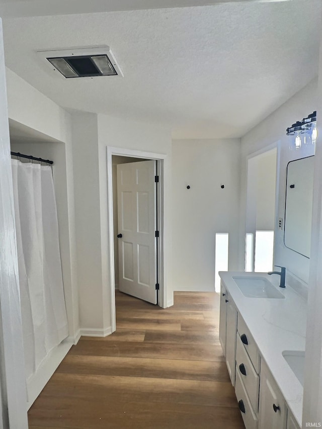 bathroom with vanity, a textured ceiling, and hardwood / wood-style floors