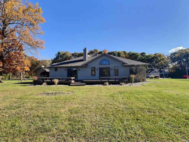 rear view of house featuring a deck and a lawn