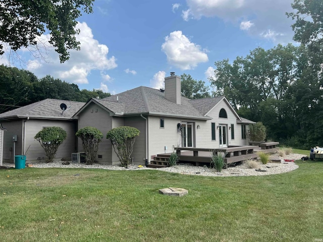 rear view of house with a wooden deck and a yard