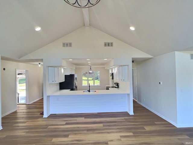 kitchen with kitchen peninsula, an inviting chandelier, white cabinetry, dark hardwood / wood-style floors, and stainless steel appliances