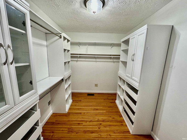 spacious closet with dark hardwood / wood-style floors