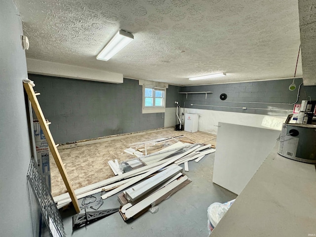 kitchen featuring concrete block wall, a textured ceiling, and concrete flooring