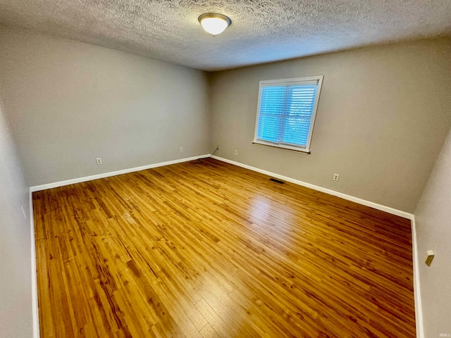 unfurnished room featuring hardwood / wood-style floors and a textured ceiling