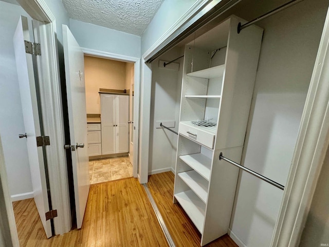 spacious closet featuring light wood-style flooring