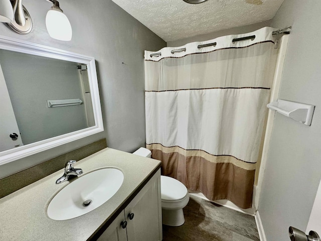 bathroom with toilet, a textured ceiling, a shower with shower curtain, and vanity