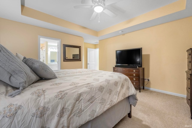 carpeted bedroom featuring ceiling fan and a tray ceiling