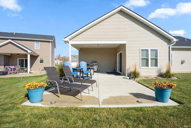 rear view of property with a yard and a patio