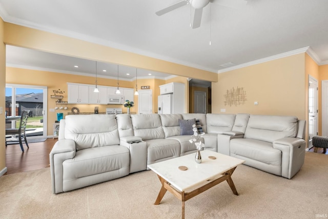 living room with crown molding, light hardwood / wood-style flooring, and ceiling fan