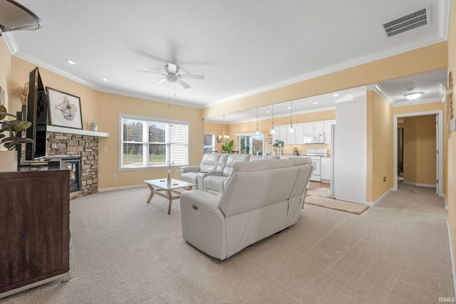 living room featuring ceiling fan with notable chandelier, a stone fireplace, ornamental molding, and light carpet