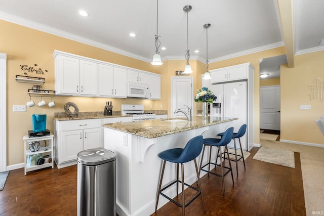 kitchen with a center island with sink, decorative light fixtures, white cabinetry, and white appliances