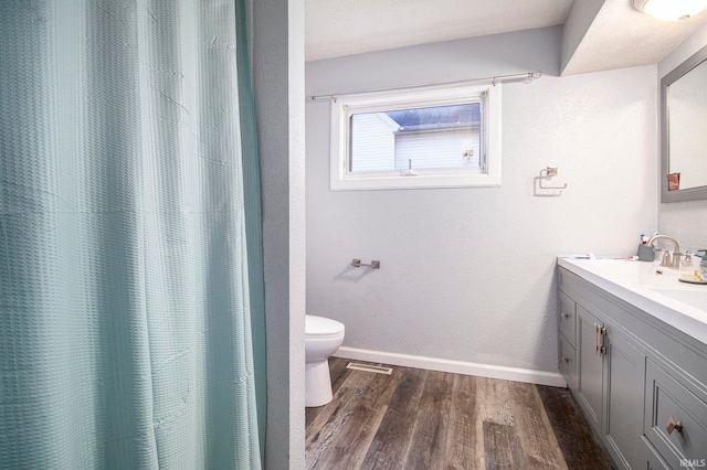 bathroom with toilet, walk in shower, vanity, and wood-type flooring