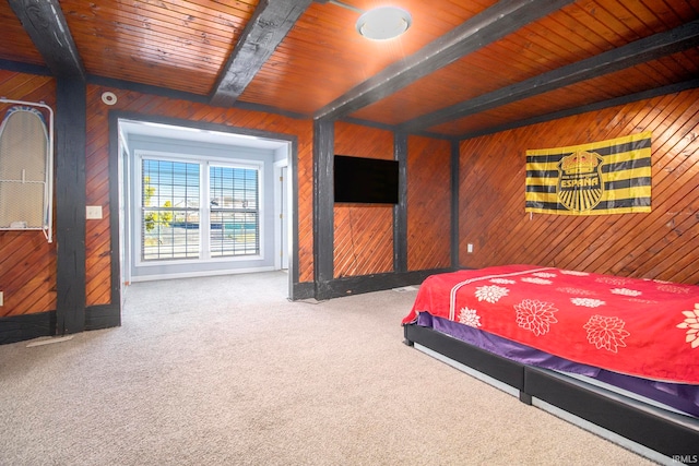 carpeted bedroom with beam ceiling, wooden walls, and wood ceiling