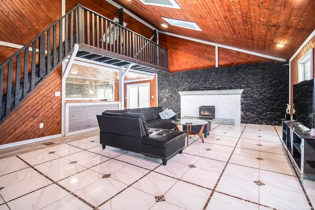 living room featuring wood ceiling, a healthy amount of sunlight, vaulted ceiling with skylight, and a wood stove