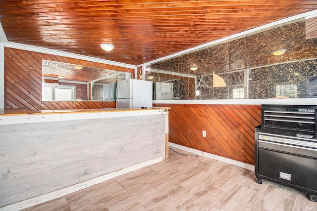 kitchen featuring white refrigerator, wooden ceiling, and wood walls