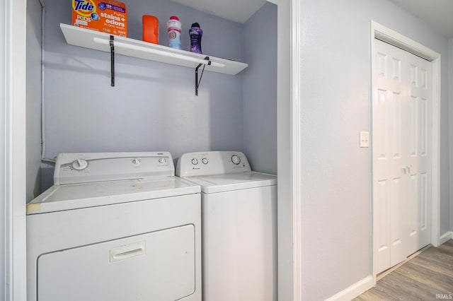 washroom featuring light hardwood / wood-style flooring and washing machine and clothes dryer