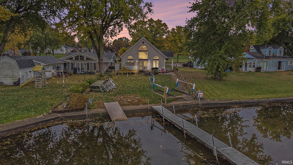 dock area with a water view and a lawn