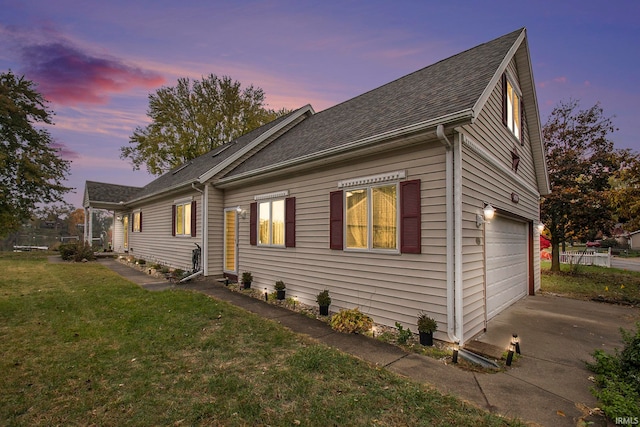 property exterior at dusk featuring a lawn and a garage