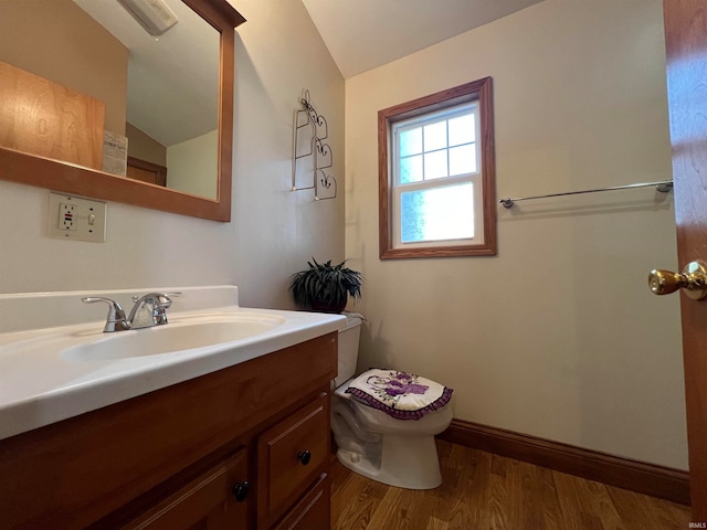 bathroom with vanity, lofted ceiling, hardwood / wood-style flooring, and toilet