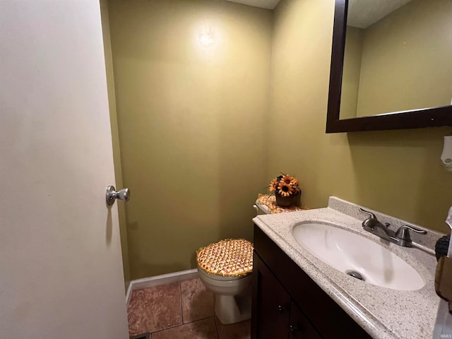 bathroom with toilet, vanity, and tile patterned floors