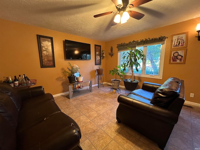 tiled living room with ceiling fan and a textured ceiling