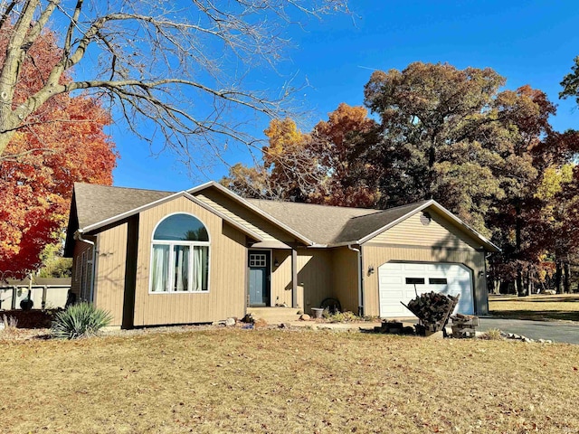 ranch-style home with a garage and a front lawn