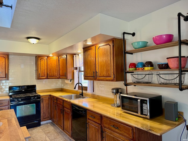 kitchen featuring black appliances, sink, backsplash, a textured ceiling, and wooden counters