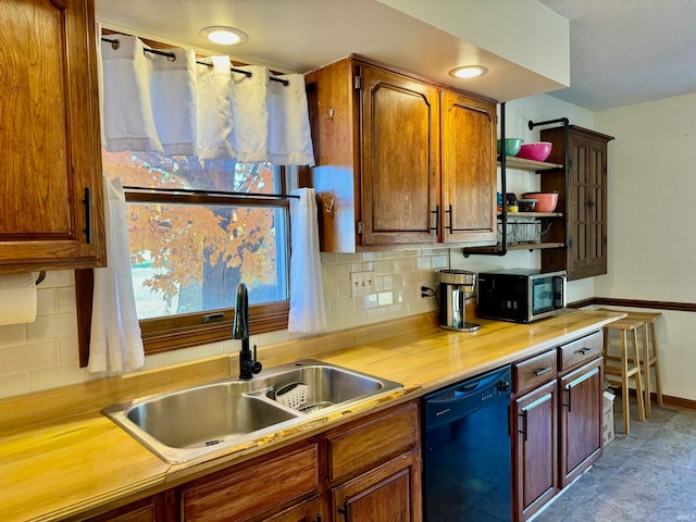 kitchen with black dishwasher, sink, and backsplash