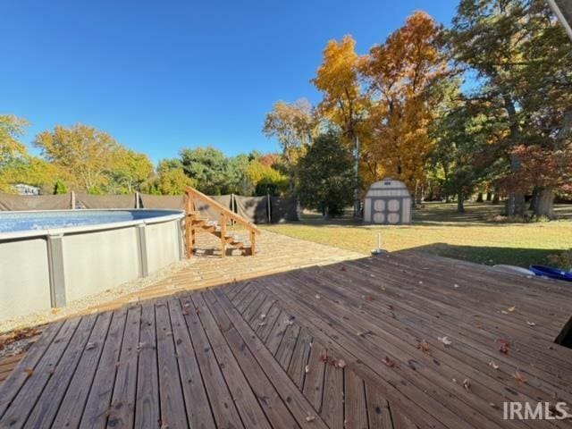 deck featuring a shed and a lawn