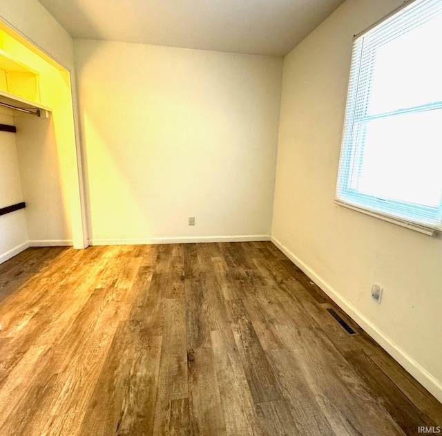 unfurnished bedroom featuring a closet and hardwood / wood-style flooring