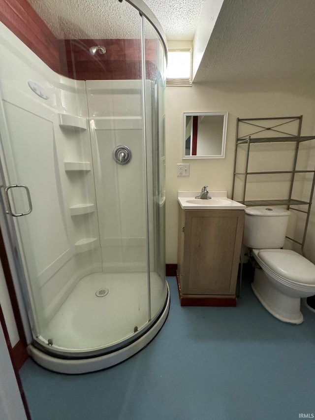 bathroom featuring vanity, toilet, a textured ceiling, and a shower with shower door