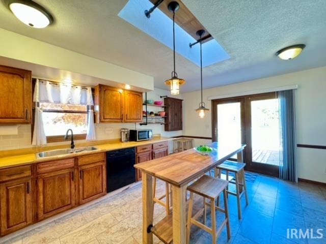 kitchen featuring black dishwasher, sink, plenty of natural light, and pendant lighting