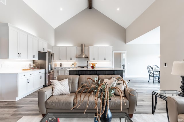 living room featuring beamed ceiling, high vaulted ceiling, and light hardwood / wood-style floors